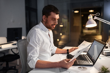 Image showing businessman with laptop working at night office