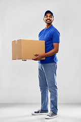 Image showing happy indian delivery man with parcel box in blue