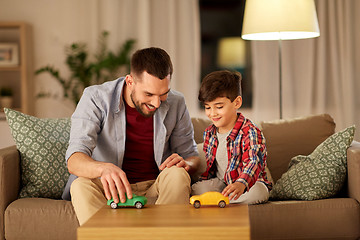 Image showing father and son playing with toy cars at home