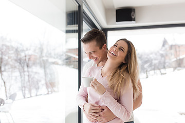 Image showing young couple enjoying morning coffee by the window