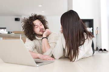 Image showing young multiethnic couple using a laptop on the floor