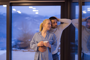 Image showing young couple enjoying evening tea by the window