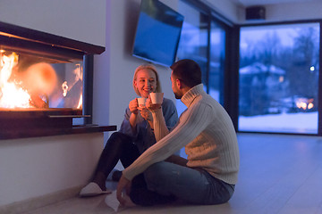 Image showing happy couple in front of fireplace