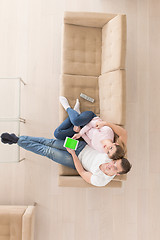 Image showing young couple in living room using tablet top view