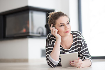 Image showing woman using tablet computer in front of fireplace