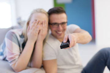 Image showing Young couple on the sofa watching television