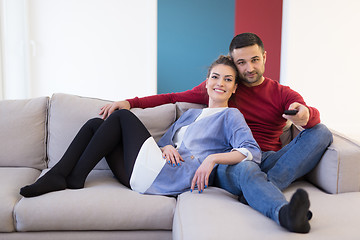 Image showing Young couple on the sofa watching television