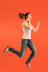 Image showing Full length of pretty young woman with mobile phone while jumping