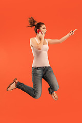 Image showing Full length of pretty young woman with mobile phone while jumping