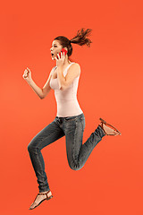 Image showing Full length of pretty young woman with mobile phone while jumping