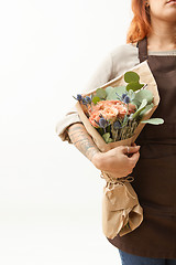 Image showing Woman with red hair holds beautiful colourful blossoming flower bouquet of fresh roses living coral color on a white background. Copy space. Mother\'s Day.