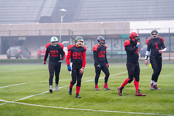 Image showing confident American football players leaving the field