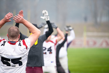 Image showing american football players stretching and warming up