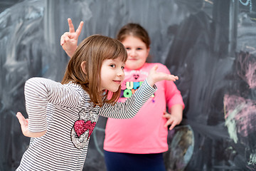 Image showing little girls having fun in front of chalkboard