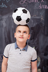 Image showing happy boy holding a soccer ball on his head