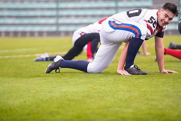 Image showing american football players stretching and warming up