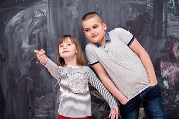 Image showing boy and little girl standing in front of chalkboard