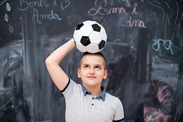 Image showing happy boy holding a soccer ball on his head