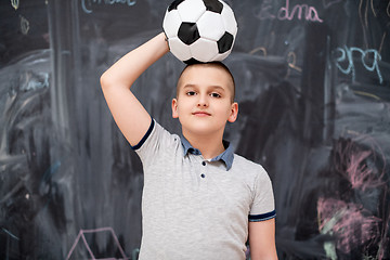 Image showing happy boy holding a soccer ball on his head