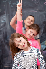 Image showing group of kids standing in front of chalkboard