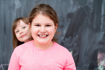 Image showing little girls having fun in front of chalkboard