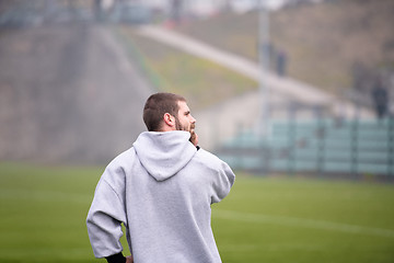 Image showing american football player warming up and stretching