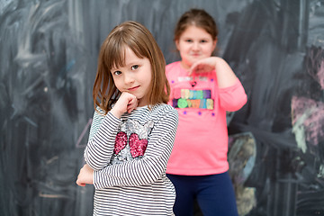 Image showing portrait of little girls in front of chalkboard