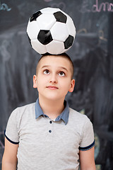 Image showing happy boy holding a soccer ball on his head