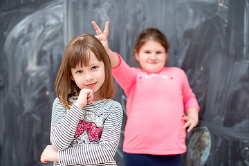 Image showing little girls having fun in front of chalkboard