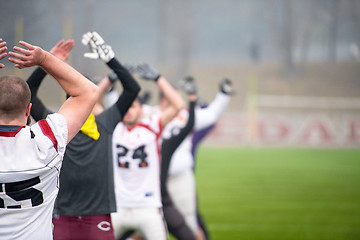 Image showing american football players stretching and warming up