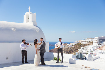 Image showing Bride and groom dansing on wedding ceremony on Santorini island, Greece.