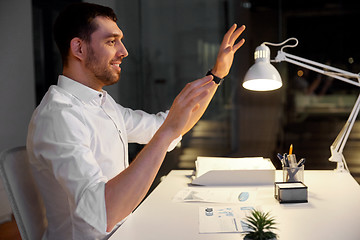 Image showing businessman using gestures at night office