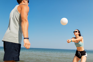 Image showing happy couple playing volleyball on summer beach