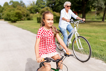 Image showing grandmother and granddaughter cycling at park