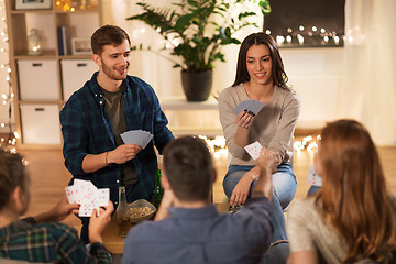 Image showing friends playing cards game at home in evening