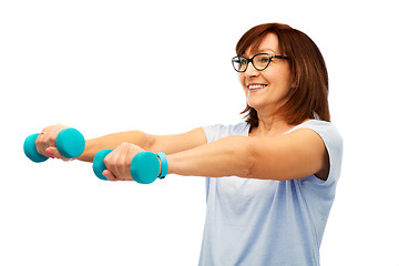 Image showing smiling senior woman with dumbbells exercising