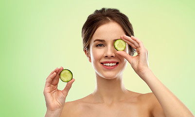 Image showing smiling woman with cucumber over green background