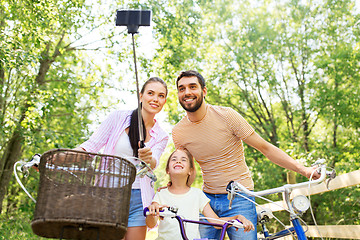 Image showing happy family with bicycles taking selfie in summer