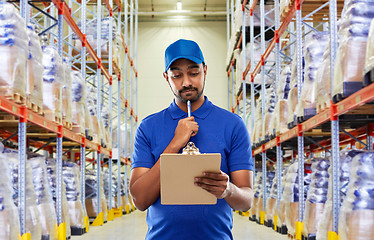 Image showing indian delivery man with clipboard at warehouse