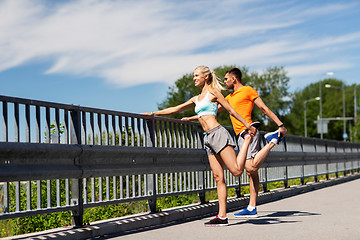 Image showing smiling couple stretching outdoors