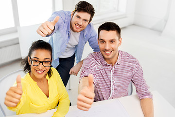 Image showing happy creative team showing thumbs up at office