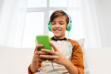 Image showing happy boy with smartphone and headphones at home