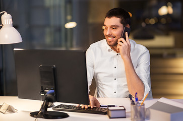 Image showing businessman calling on smartphone at night office