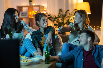 Image showing friends with drinks and snacks watching tv at home