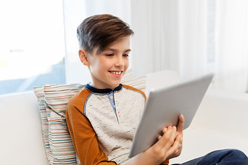 Image showing smiling boy with tablet pc computer at home