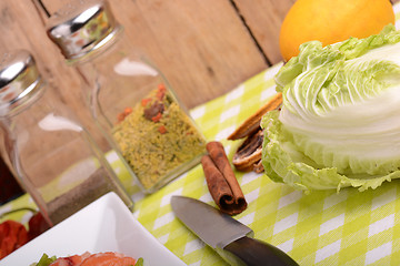 Image showing fresh salmon fillet on white plate. knife, cabbage, red pepper, spice, cinnamon and lemon