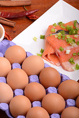 Image showing fresh salmon fillet close up on white plate. red pepper, eggs and lemon