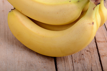 Image showing bunch of yellow Bananas in a Wooden background