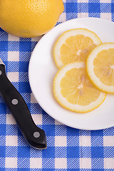 Image showing Halved lemon and a knife on a white plate