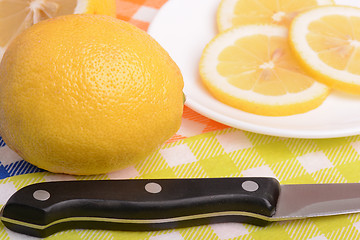 Image showing Halved lemon and a knife on a white plate